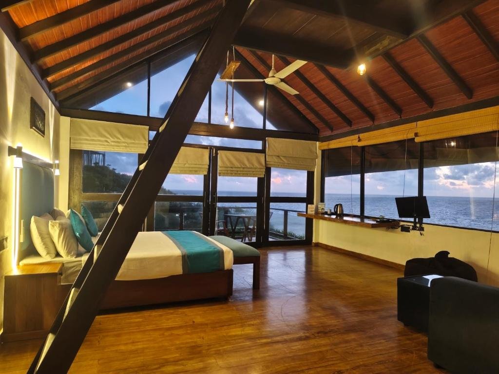 Sea-facing bedroom with timber ceiling and seating